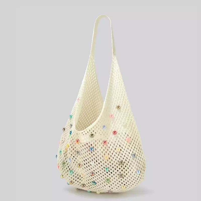 Bolsa de crochê de praia Lavinni Capri Pearl na cor branca com formato hobo/balde e aplicações de pérolas coloridas.