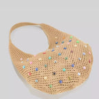 Bolsa de crochê Lavinni Capri Pearl na cor cáqui deitada de lado, destacando o design vazado em formato balde e as pérolas coloridas aplicadas.