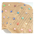 Close-up da bolsa de praia chique Lavinni Capri Pearl em tom cáqui, destacando a textura tricotada da malha vazada e a aplicação das pérolas coloridas.