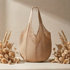 Bolsa de praia de crochê Lavinni Amalfi Mesh em tom areia posicionada em cenário decorativo com arranjos rústicos de flores secas.