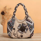 Bolsa de praia rústica Lavinni Vintage Bloom em tecido bege com bordados florais e geométricos em cenário decorativo.